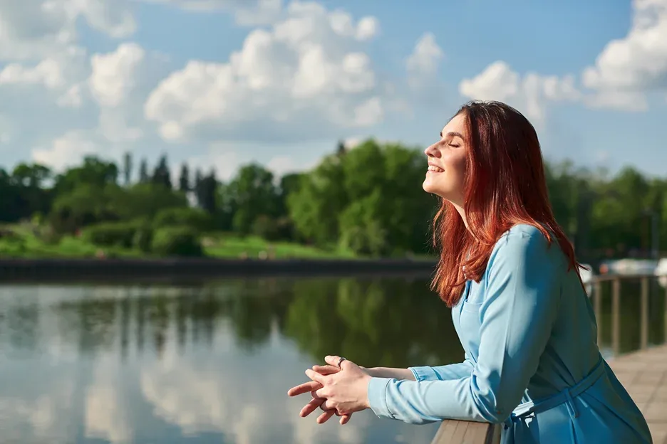 a portrait of woman standing leisurely beside the lake