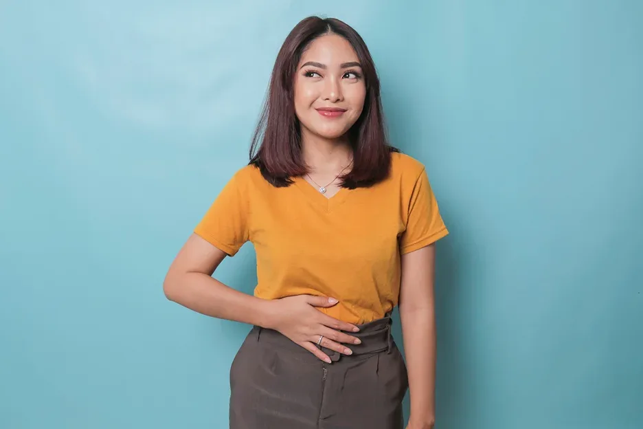 a happy woman touching her tummy