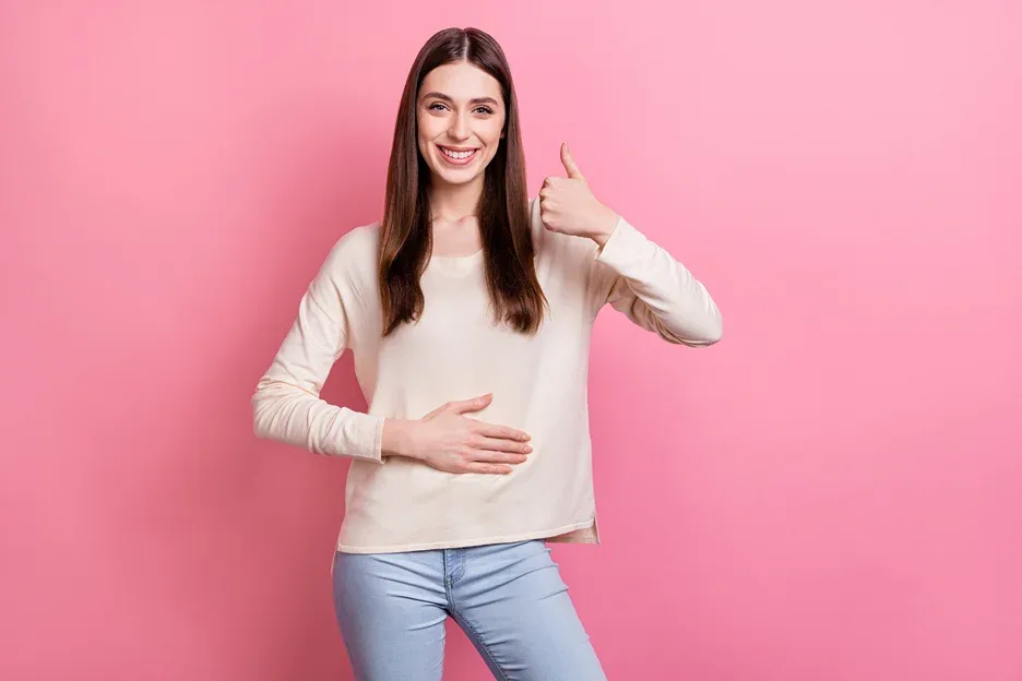 a portrait of a happy woman holding her belly