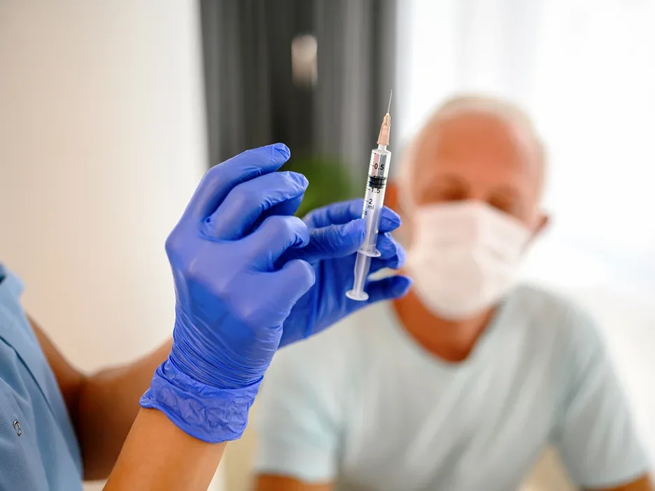 medical provider prepares the vaccine to inject on the patient