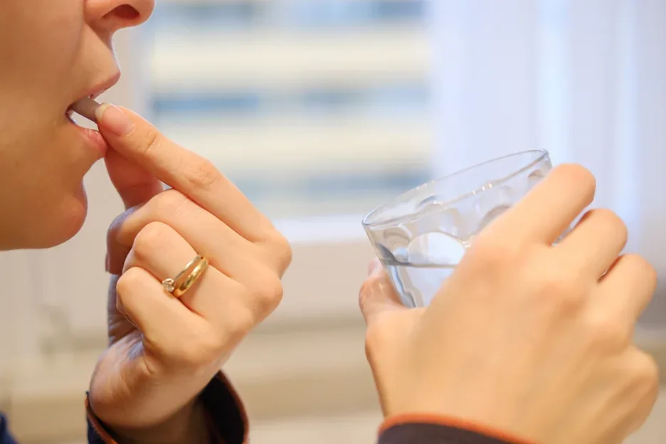 a woman taking a pill