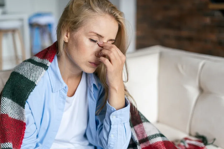 a woman massaging her nose bridge to alleviate pain