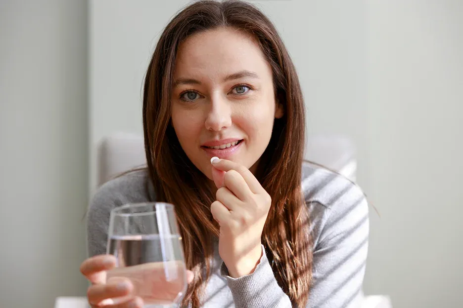 a woman taking a supplement